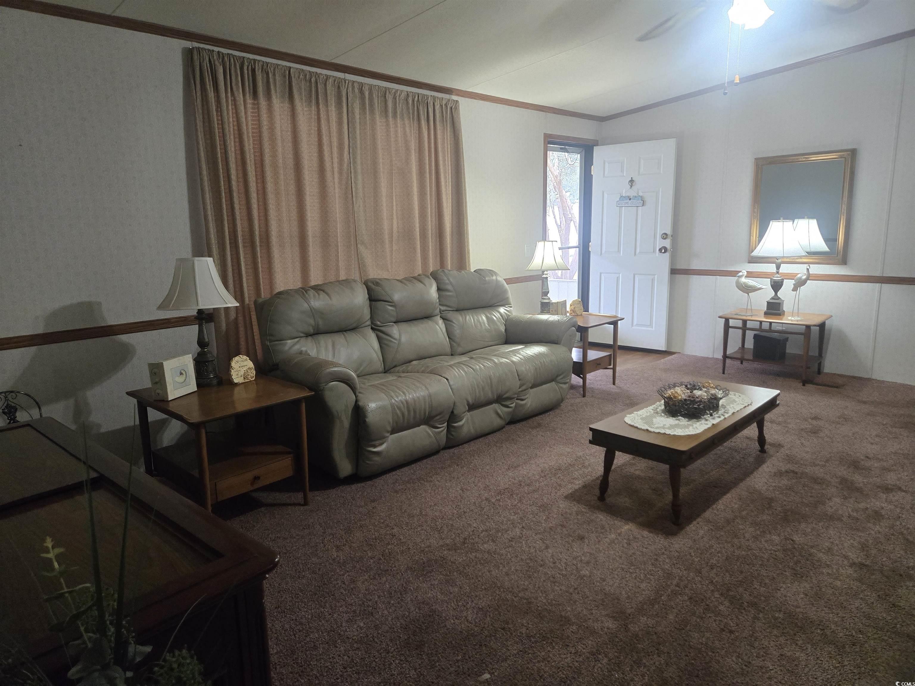 326 Tunnoch Road Murrells Inlet, SC 29576 - Photo 8 of 22 Living area with carpet flooring, a ceiling fan, ornamental molding, and vaulted ceiling