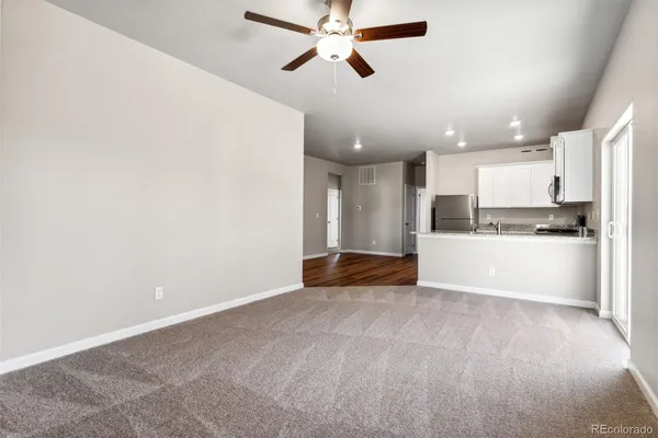 a view of kitchen with kitchen island stainless steel appliances wooden floor cabinets and window