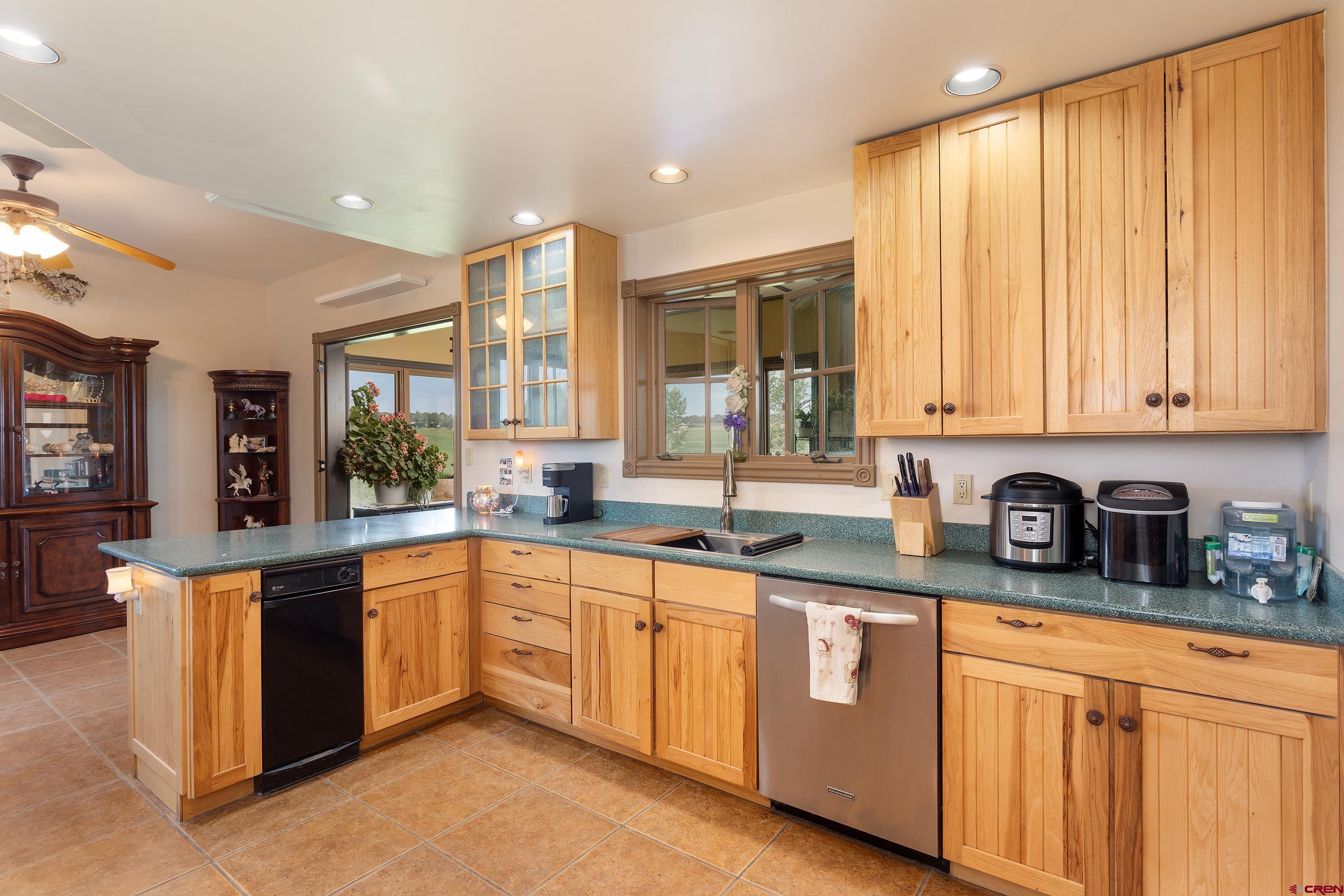 1747 County Road 514 Ignacio, CO 81137 - Photo 9 of 35 a kitchen with stainless steel appliances granite countertop wooden cabinets a sink and a large window