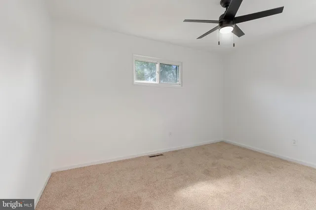 a view of an empty room and a ceiling fan