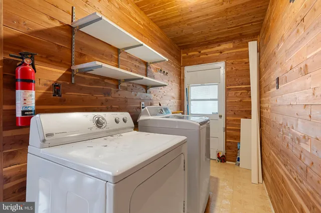 a backyard of a house with table and chairs plants and large tree