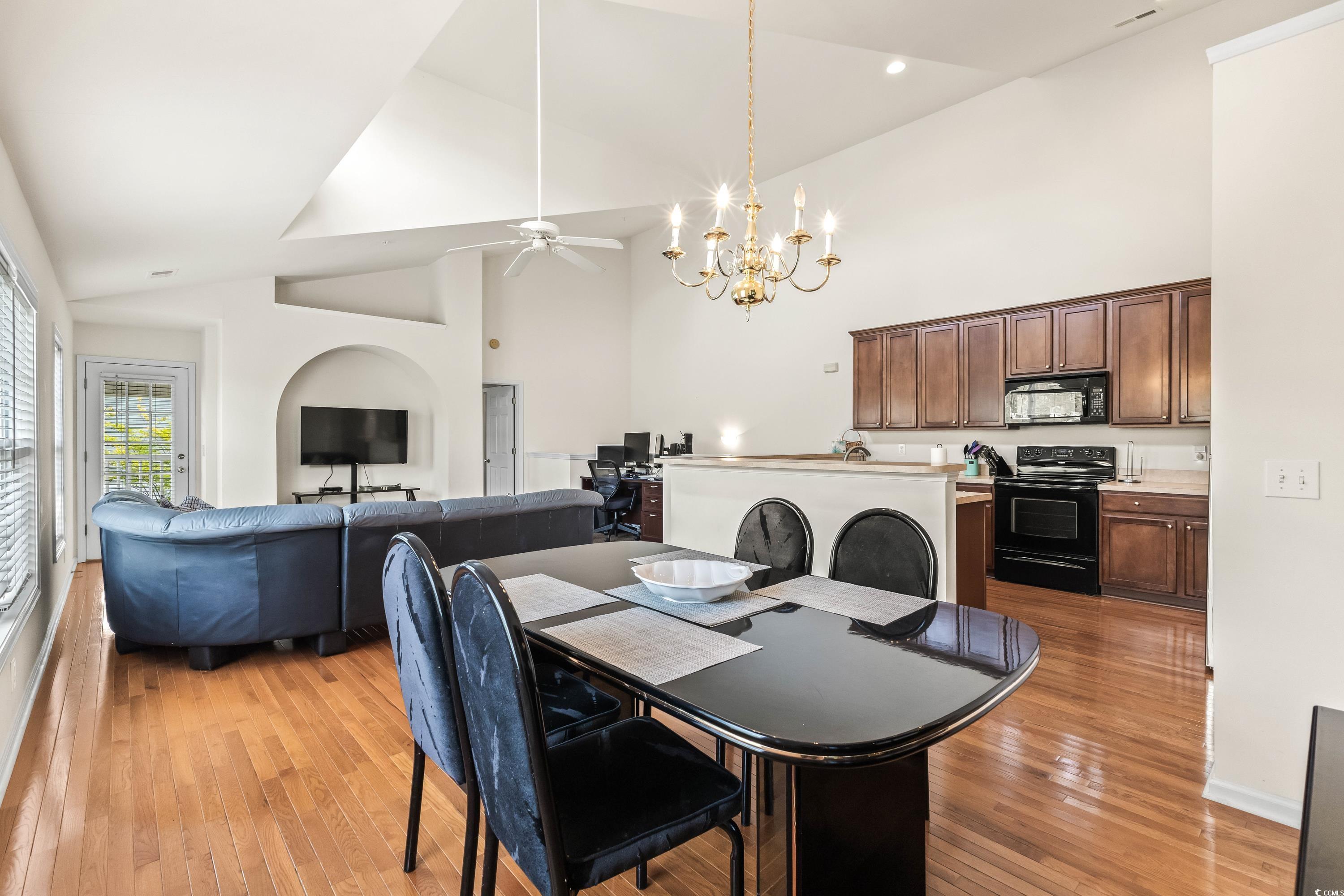 400 Black Smith Lane, Unit A Myrtle Beach, SC 29579 - Photo 11 of 35 Dining room featuring ceiling fan, a chandelier, light wood finished floors, and high vaulted ceiling