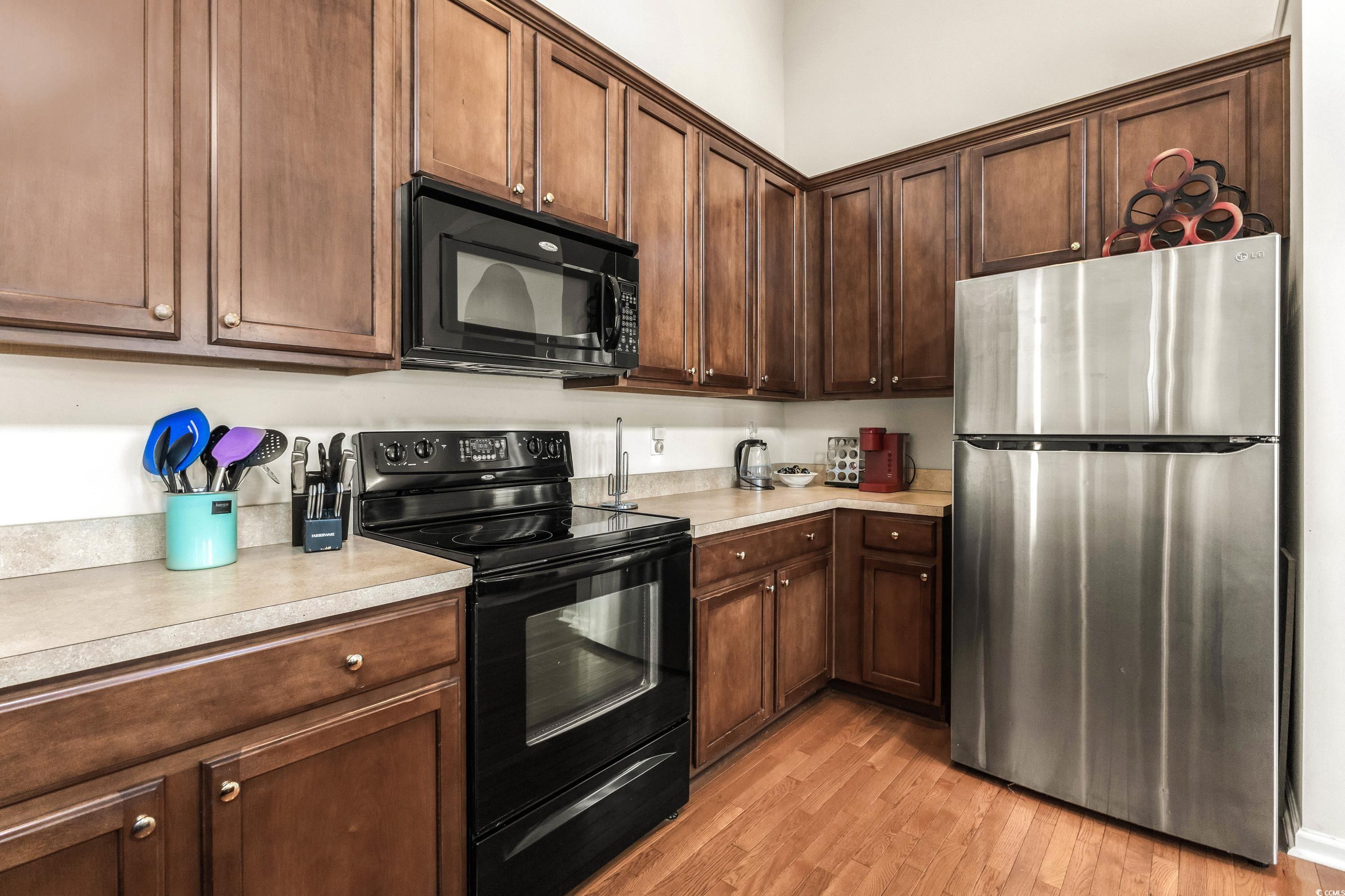 400 Black Smith Lane, Unit A Myrtle Beach, SC 29579 - Photo 15 of 35 Kitchen featuring black appliances, light countertops, light wood-style floors, and dark brown cabinets