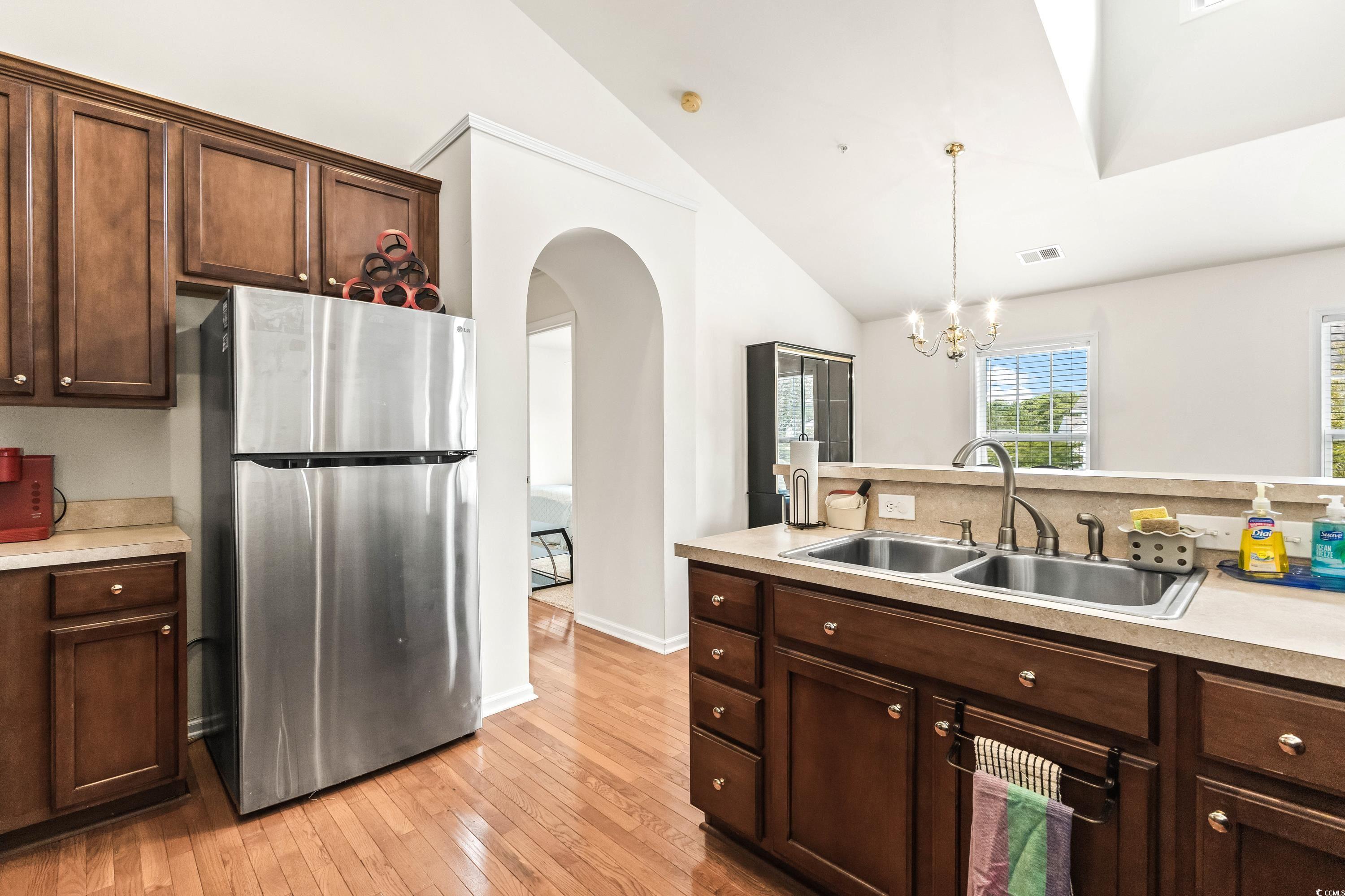 400 Black Smith Lane, Unit A Myrtle Beach, SC 29579 - Photo 16 of 35 Kitchen with freestanding refrigerator, light countertops, arched walkways, light wood-type flooring, and high vaulted ceiling