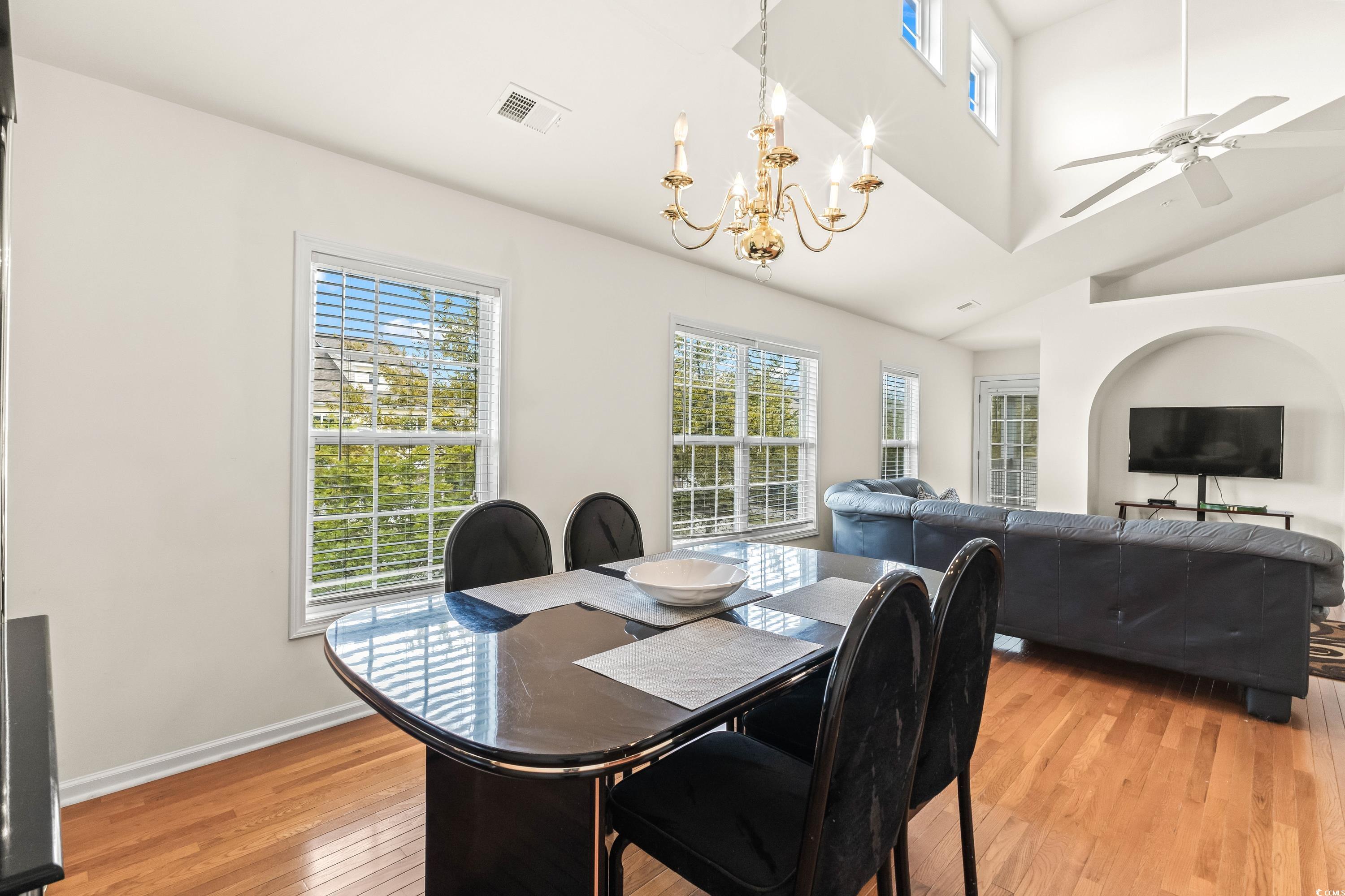 400 Black Smith Lane, Unit A Myrtle Beach, SC 29579 - Photo 10 of 35 Dining area with light wood-style floors, ceiling fan, high vaulted ceiling, and a chandelier