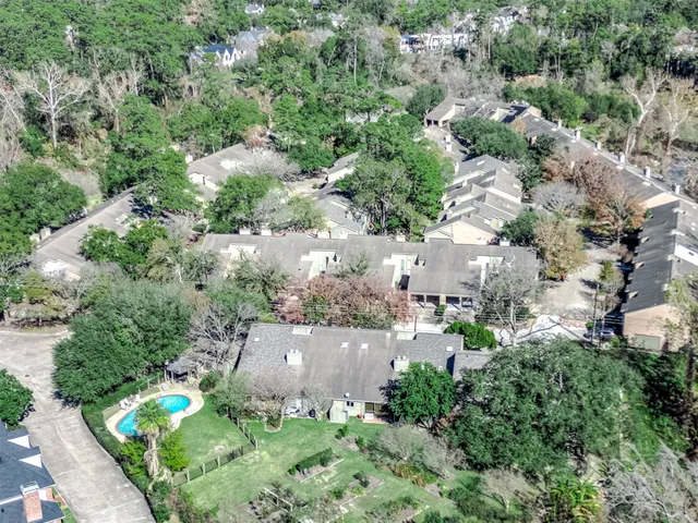 an aerial view of residential house with outdoor space and trees all around
