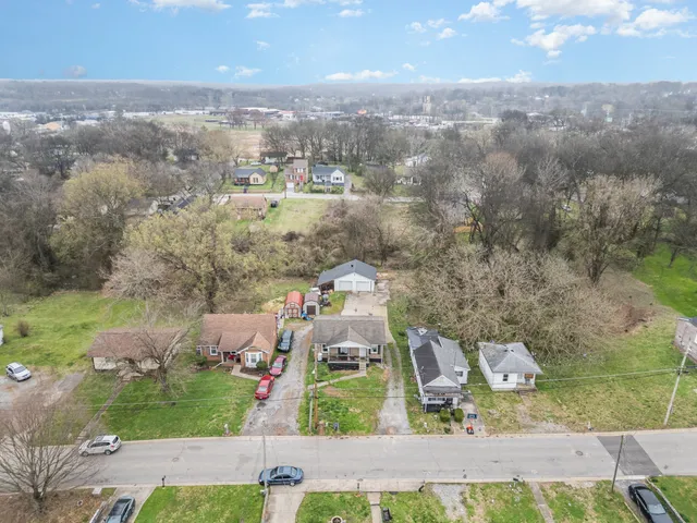 an aerial view of residential houses with outdoor space and parking