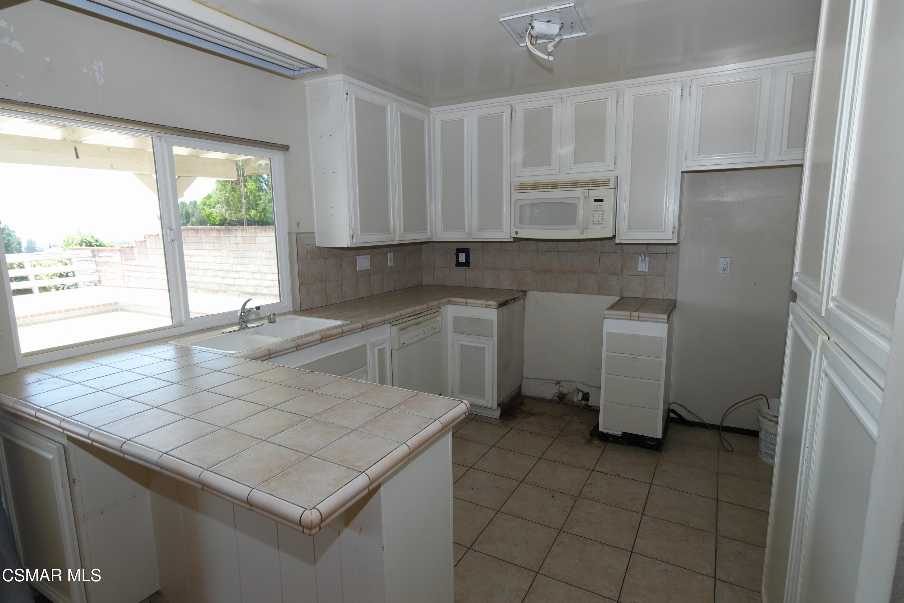 18550 Dylan Street Porter Ranch, CA 91326 - Photo 10 of 27 a kitchen with a sink window and cabinets