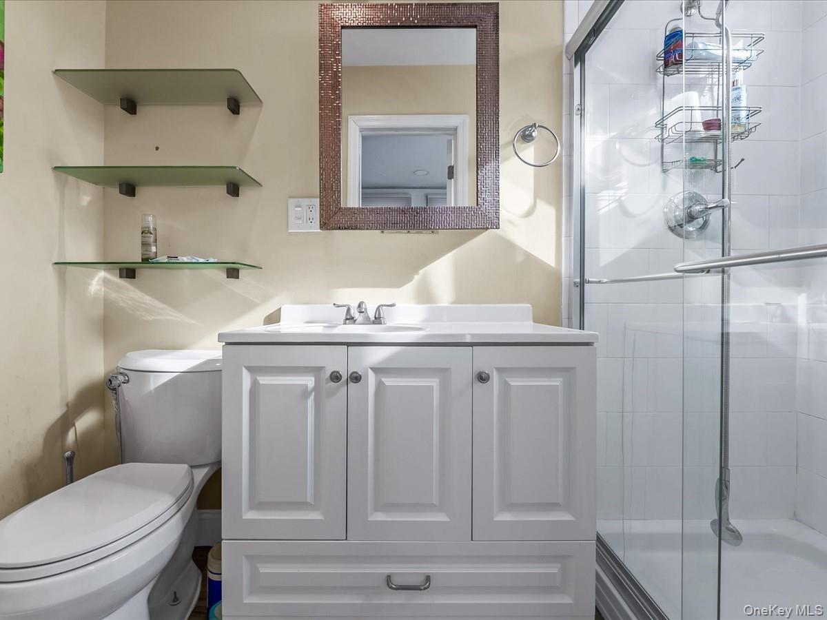 219-08 38th Avenue Queens, NY 11361 - Photo 11 of 24 a bathroom with a sink a toilet and shower