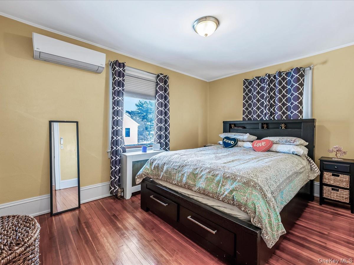 219-08 38th Avenue Queens, NY 11361 - Photo 12 of 24 a bedroom with a bed and wooden floor