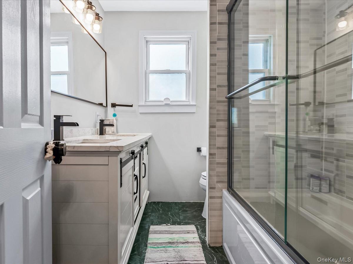 219-08 38th Avenue Queens, NY 11361 - Photo 16 of 24 a bathroom with a sink a toilet and shower