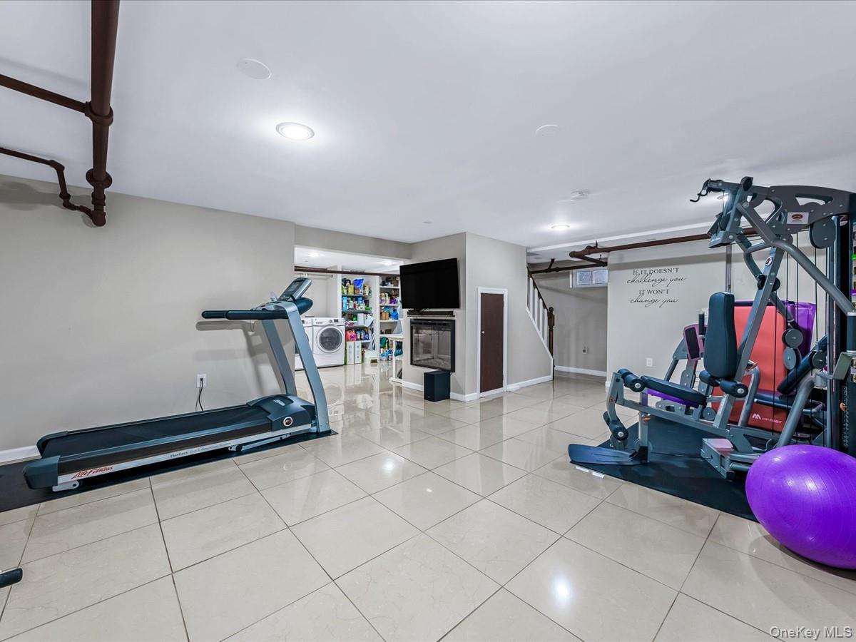 219-08 38th Avenue Queens, NY 11361 - Photo 18 of 24 a room with gym equipment and a flat screen tv