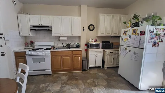 a kitchen with white cabinets and white appliances