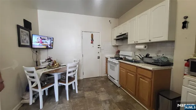 a kitchen with stainless steel appliances granite countertop a white cabinets and a stove top oven