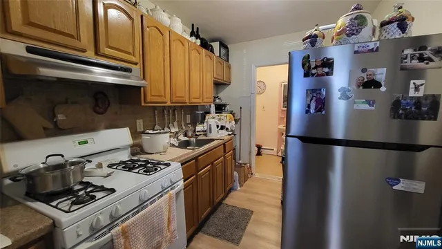 a kitchen with stainless steel appliances granite countertop a refrigerator and a stove