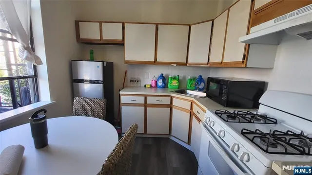 a kitchen with stainless steel appliances a refrigerator a sink a stove and cabinets