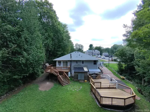 an aerial view of a house with garden space and a deck