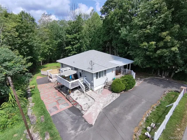 an aerial view of a house with porch yard basket ball court and slide