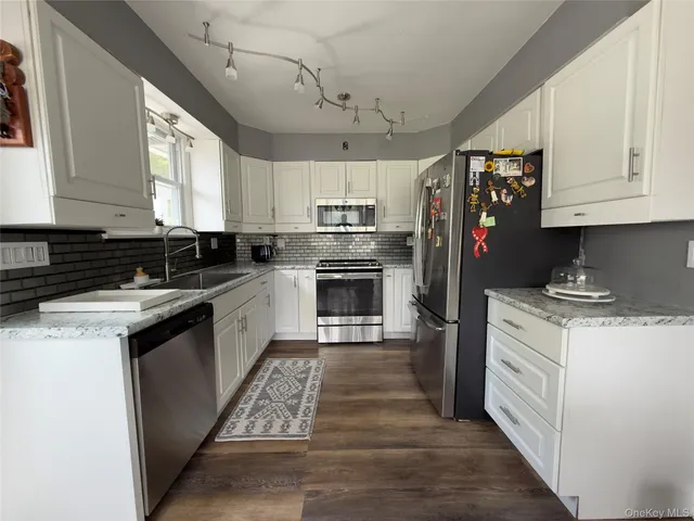 a kitchen with stainless steel appliances granite countertop a stove a sink and a refrigerator