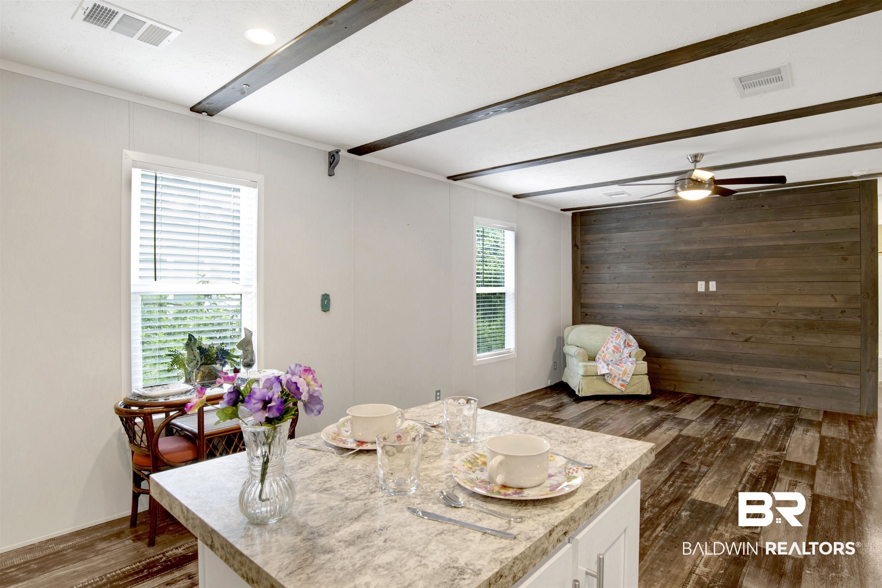 1411 Ridgewood Drive Lillian, AL 36549 - Photo 18 of 30 Dining space featuring wood walls, ceiling fan, beamed ceiling, and dark wood-type flooring