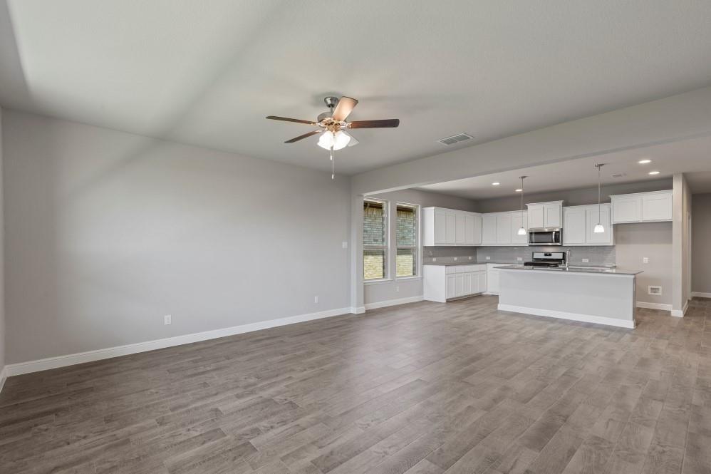 130 Lunayena Road Rhome, TX 76078 - Photo 11 of 39 a view of kitchen with refrigerator microwave and wooden floor
