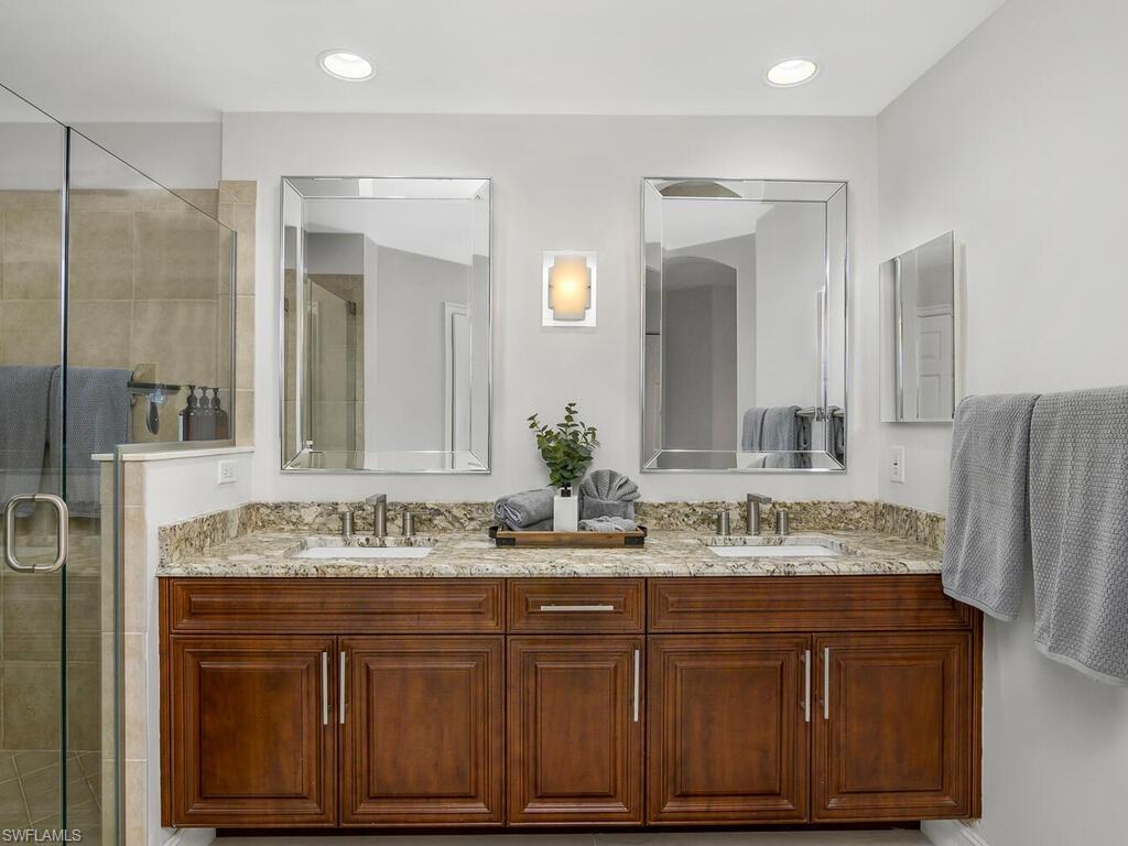 816 Carrick Bend Circle, Unit 202 Naples, FL 34110 - Photo 34 of 50 Master bath with a stall shower, double vanity, and recessed lighting