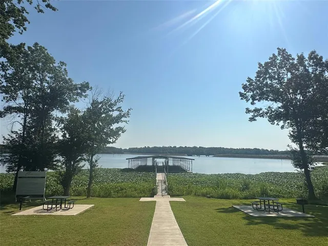a view of a lake with a big yard and large trees