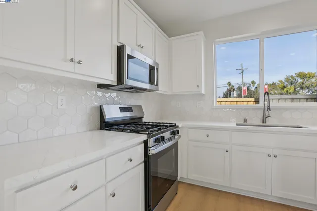 a kitchen with white cabinets and appliances