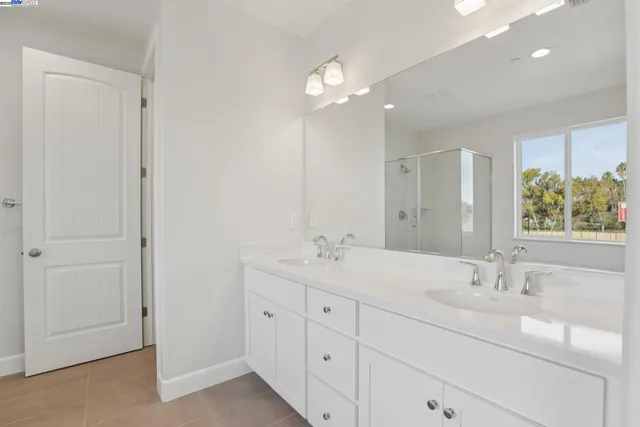 a bathroom with a sink double vanity and a mirror