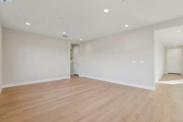 an empty room with wooden floor and entrance
