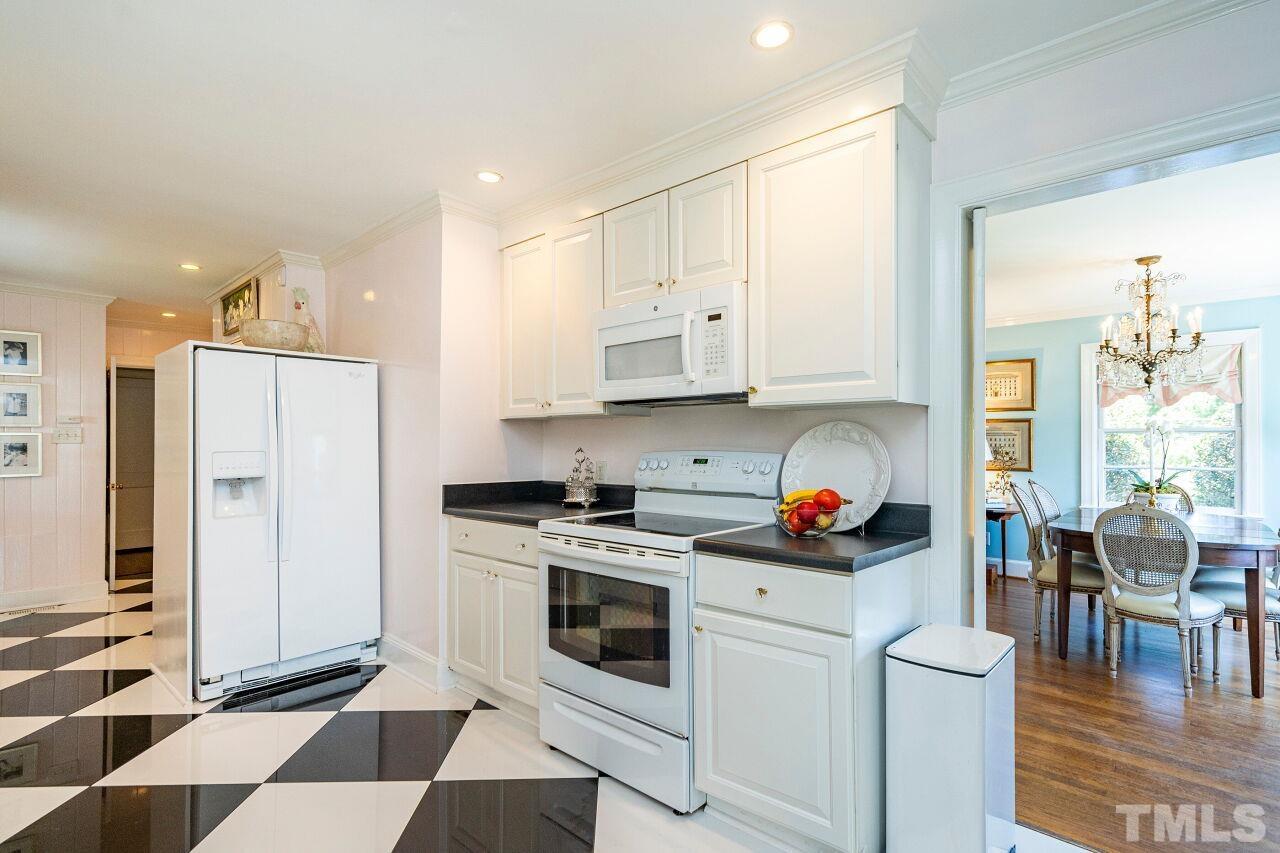 2613 Churchill Road Raleigh, NC 27608 - Photo 14 of 24 a kitchen with stainless steel appliances and white cabinets