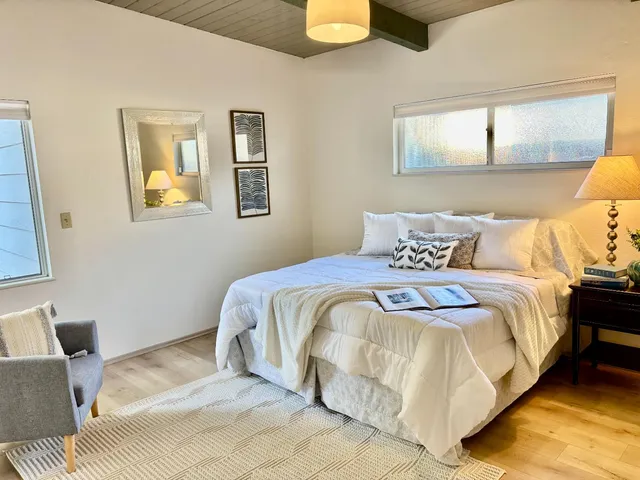 a bedroom with a bed and painting on the wall