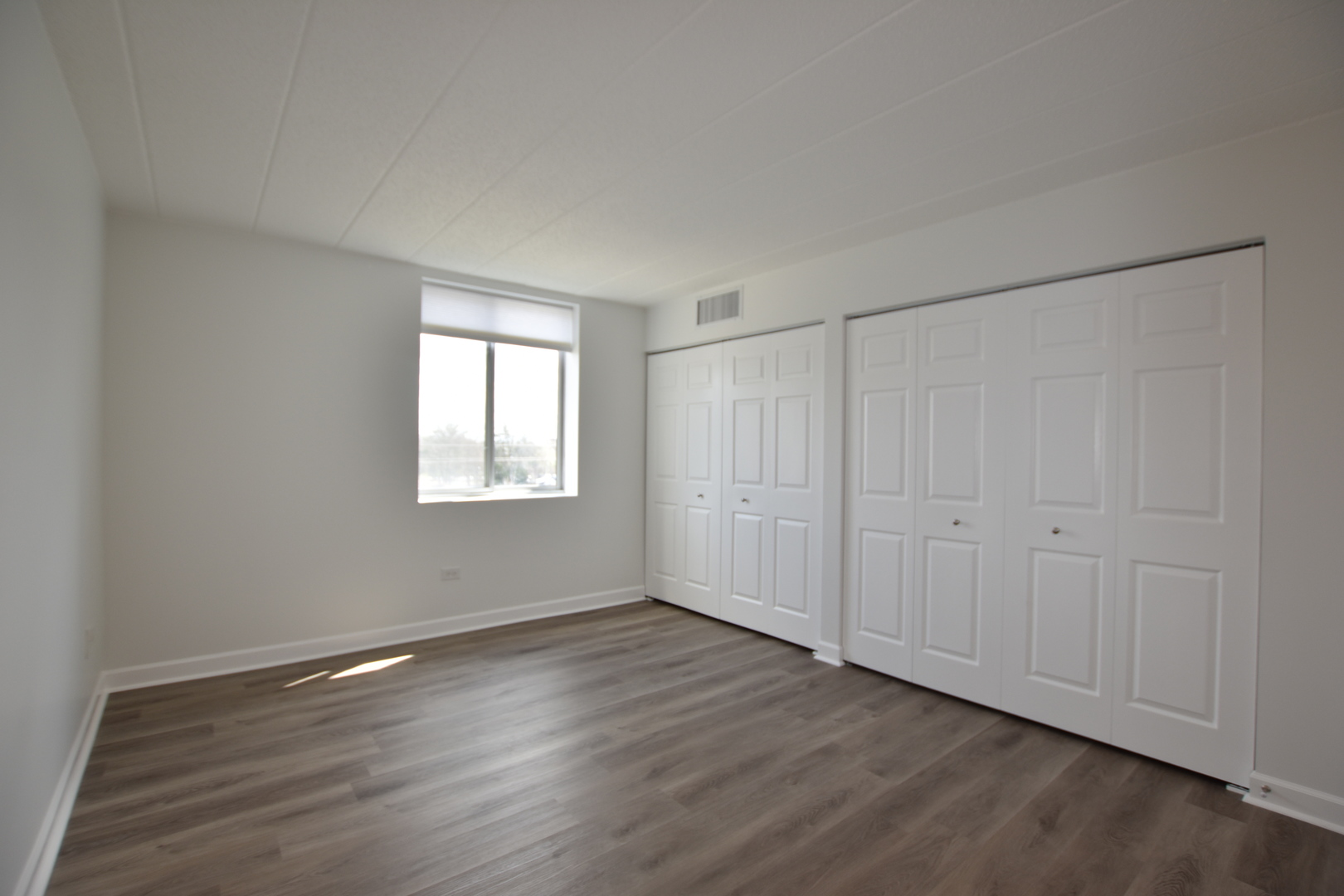 110 West Butterfield Road, Unit 506S Elmhurst, IL 60126 - Photo 20 of 30 a view of an empty room with wooden floor and a window