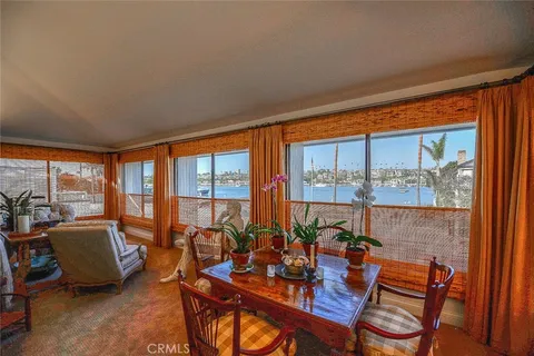 a view of a dining room with furniture large windows and wooden floor