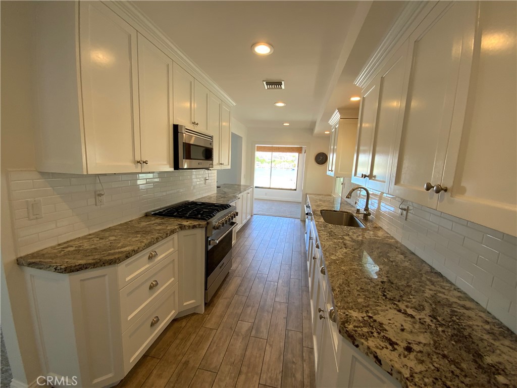 2137 Channel Road Newport Beach, CA 92661 - Photo 7 of 21 a kitchen with a stove a sink and a refrigerator