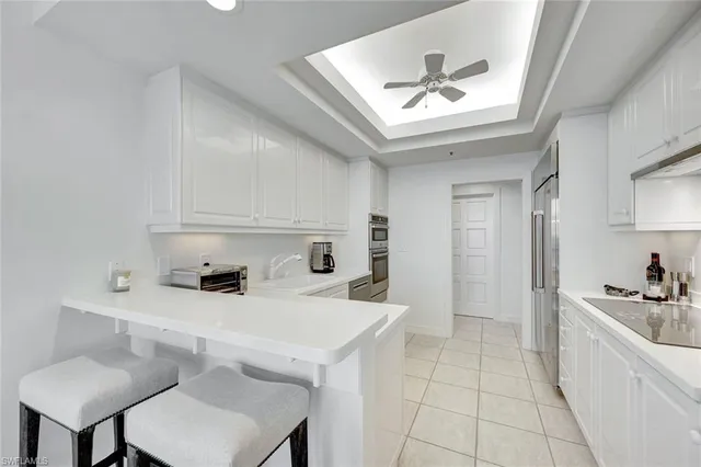 a kitchen with a sink a stove cabinets and living room view