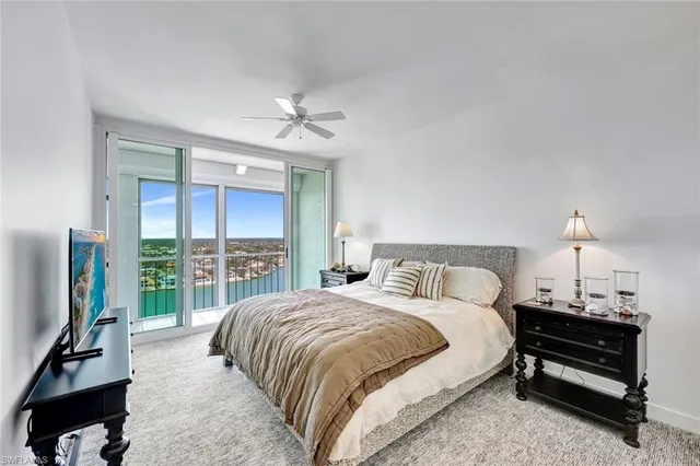 a bedroom with a bed a large window and a flat screen tv