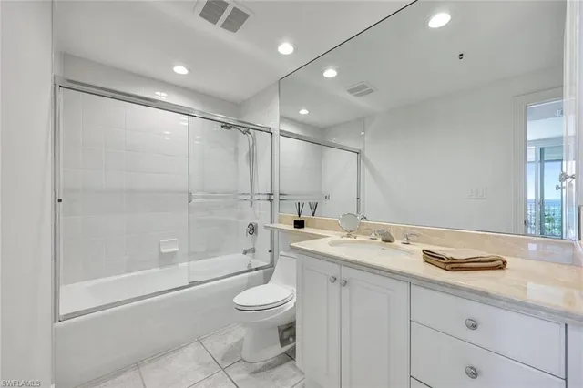 a bathroom with a granite countertop sink a toilet and shower