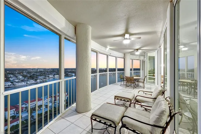 a dining room with furniture water view and a floor to ceiling window