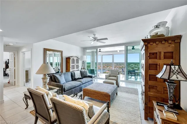 a living room with furniture a floor to ceiling window and wooden floor