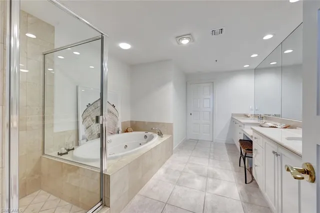 a bathroom with a tub a sink and a shower