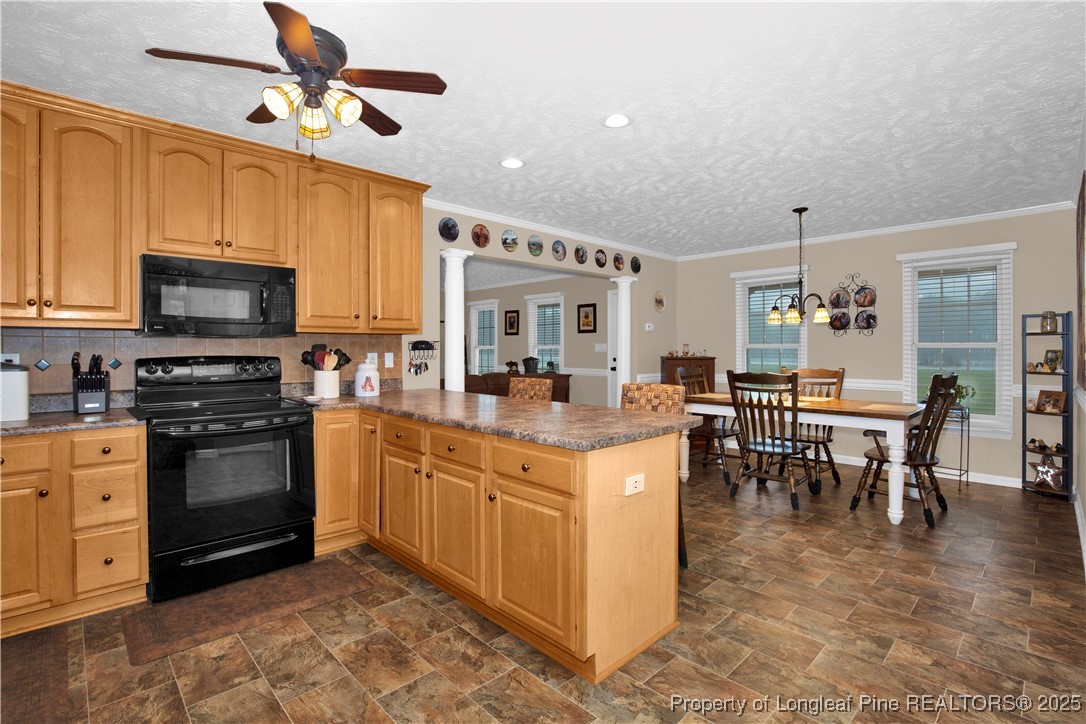 4891 Wade-Stedman Road Wade, NC 28395 - Photo 12 of 46 a kitchen with stainless steel appliances kitchen island granite countertop a stove top oven a sink a dining table and chairs with white cabinets