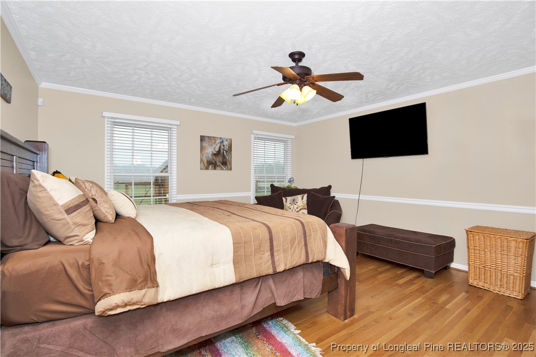 4891 Wade-Stedman Road Wade, NC 28395 - Photo 15 of 46 a bedroom with a bed a flat screen tv and a couch