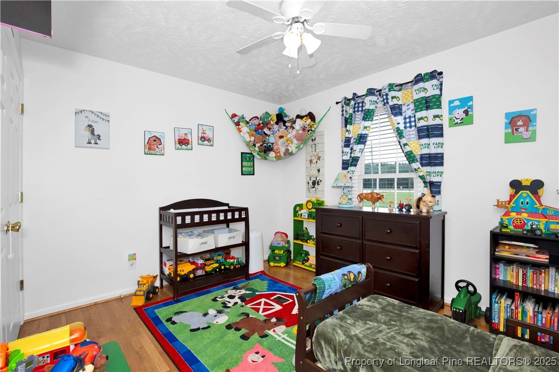 4891 Wade-Stedman Road Wade, NC 28395 - Photo 21 of 46 a bedroom with a bed and wooden floor
