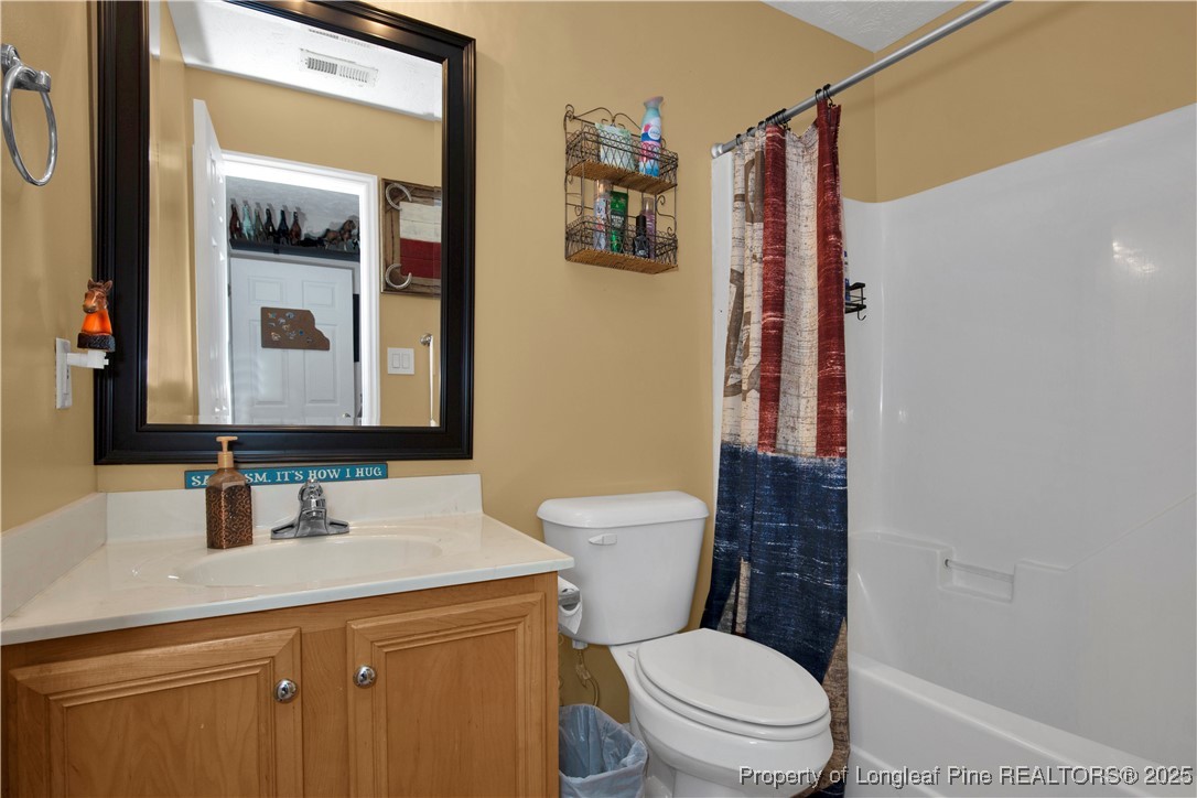 4891 Wade-Stedman Road Wade, NC 28395 - Photo 28 of 46 a bathroom with a toilet a sink and a mirror