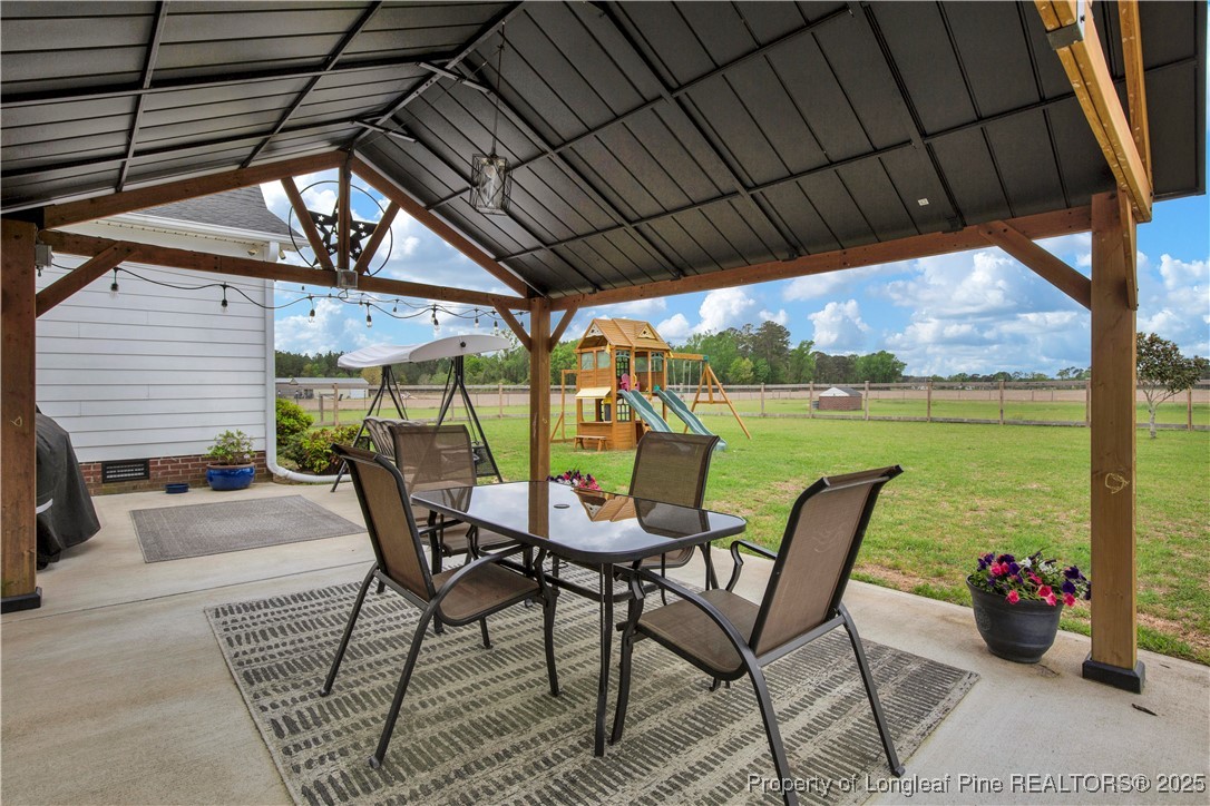 4891 Wade-Stedman Road Wade, NC 28395 - Photo 30 of 46 a view of a chairs and table in the patio next to a yard