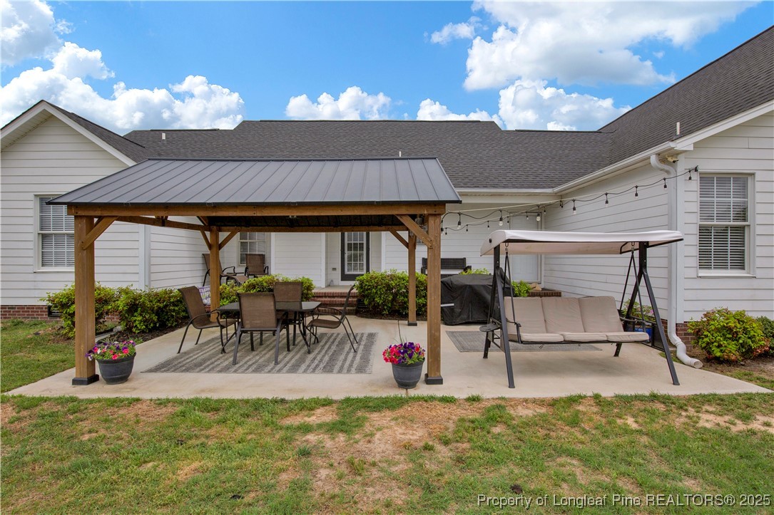 4891 Wade-Stedman Road Wade, NC 28395 - Photo 3 of 46 a view of a patio with table and chairs potted plants and a large tree