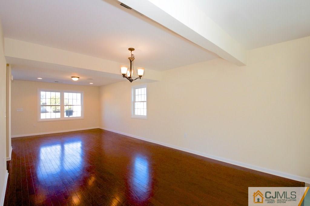 60 Ashley Road Edison, NJ 08817 - Photo 3 of 9 an empty room with wooden floor chandelier and windows