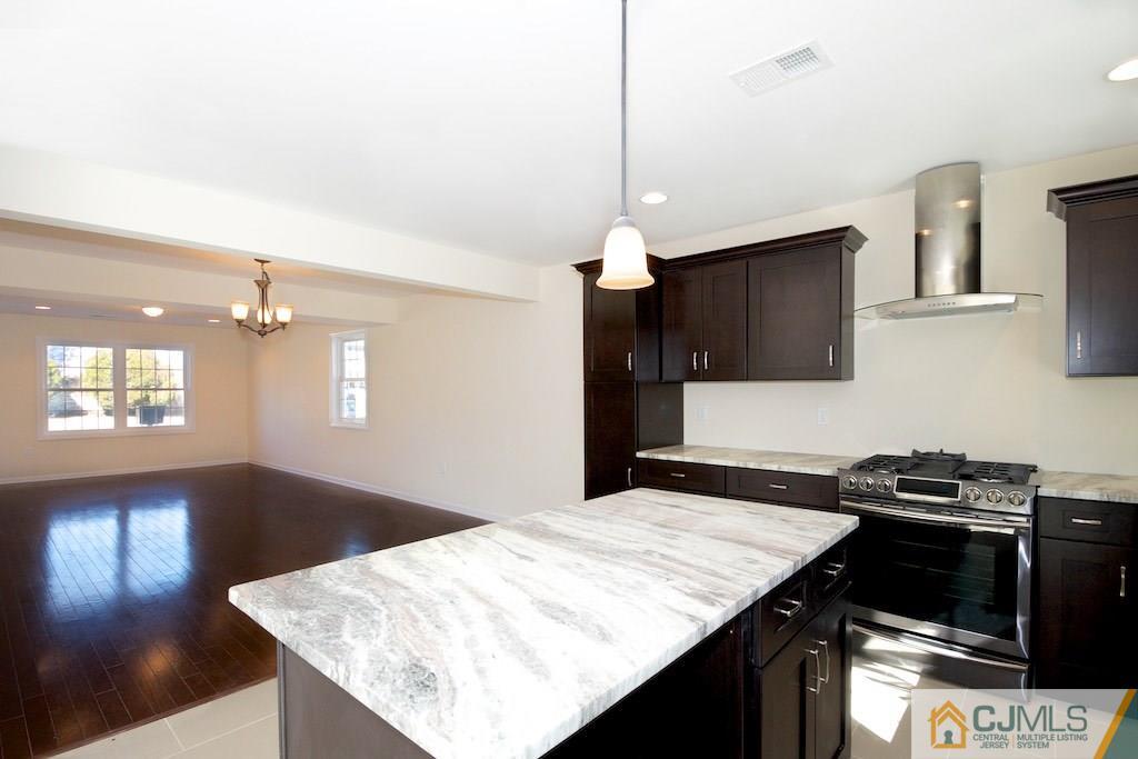 60 Ashley Road Edison, NJ 08817 - Photo 5 of 9 a kitchen with a stove and a wooden floor