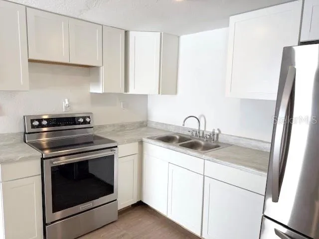 a kitchen with sink stove and cabinets